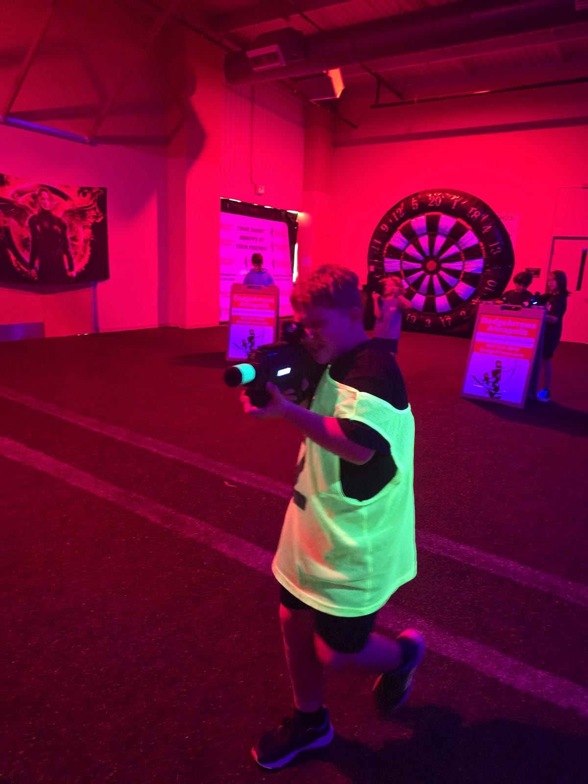 Kids gathered around a tripod-mounted foam dart blaster at DodgeArrows Annapolis