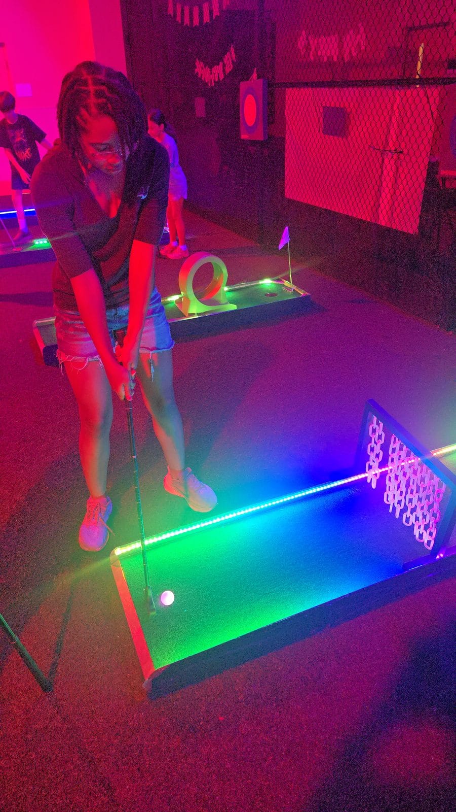Two kids in white shirts glowing bright under deep blue UV blacklight